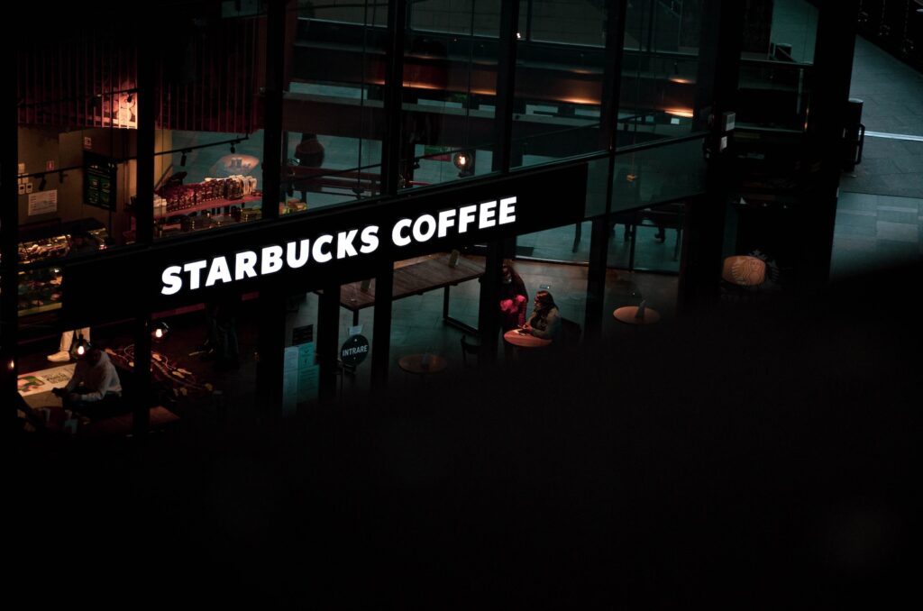 a starbucks sign hanging from the side of a building