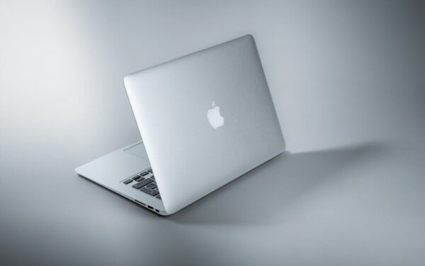 silver macbook on white table